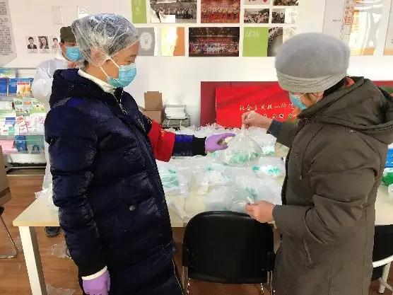 為樓棟分發(fā)口罩，并為包裝袋消毒